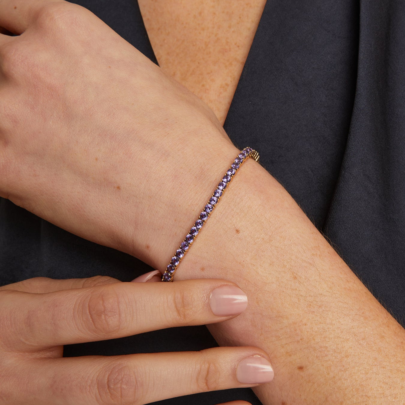 Close-up of a wrist wearing a beaded bracelet with a dark background