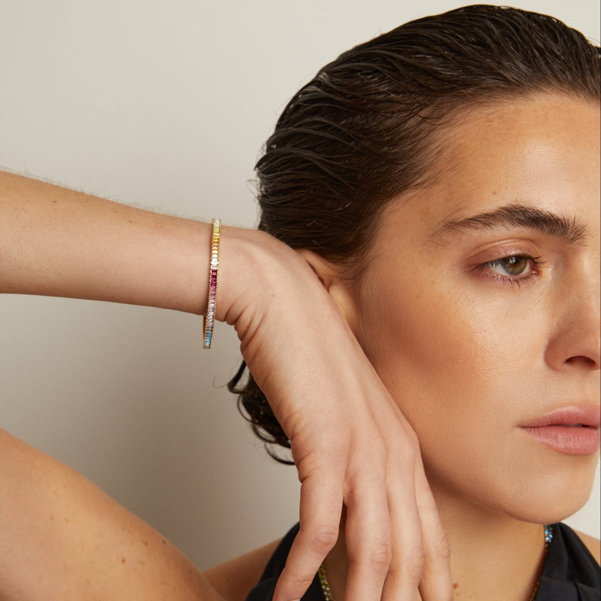 Model. Woman wearing a colorful bracelet on her wrist with a neutral background
