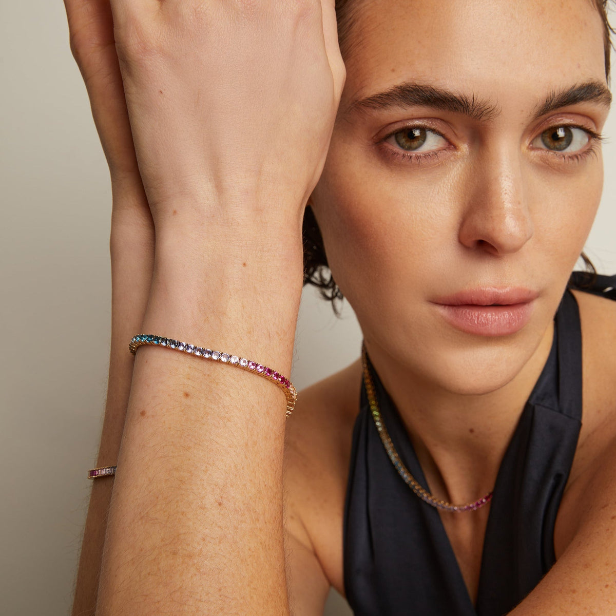 Model. Woman wearing colorful bracelets on a neutral background