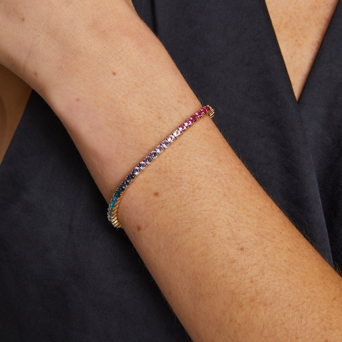 Model. Close-up of a person's arm wearing a colorful beaded bracelet on a black background