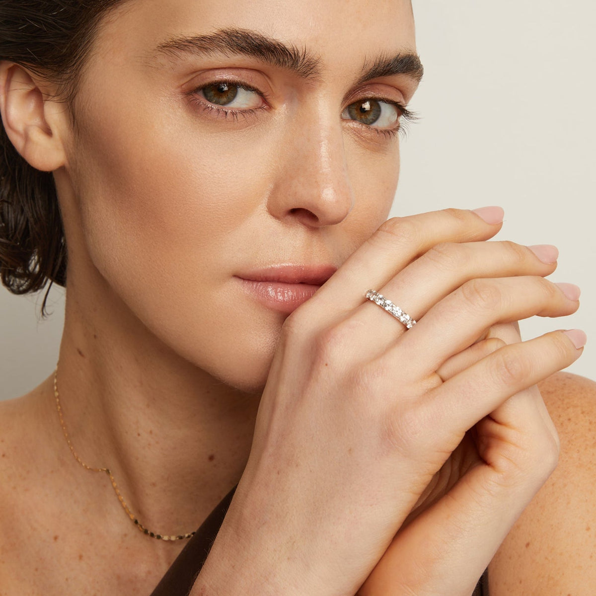 Model. Close-up of a woman wearing a diamond ring on a neutral background