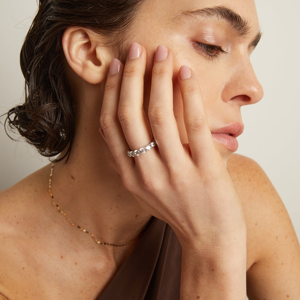 Model. Woman wearing a diamond ring with a neutral background