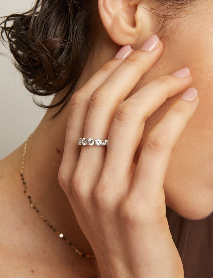 Woman wearing a diamond ring with a neutral background