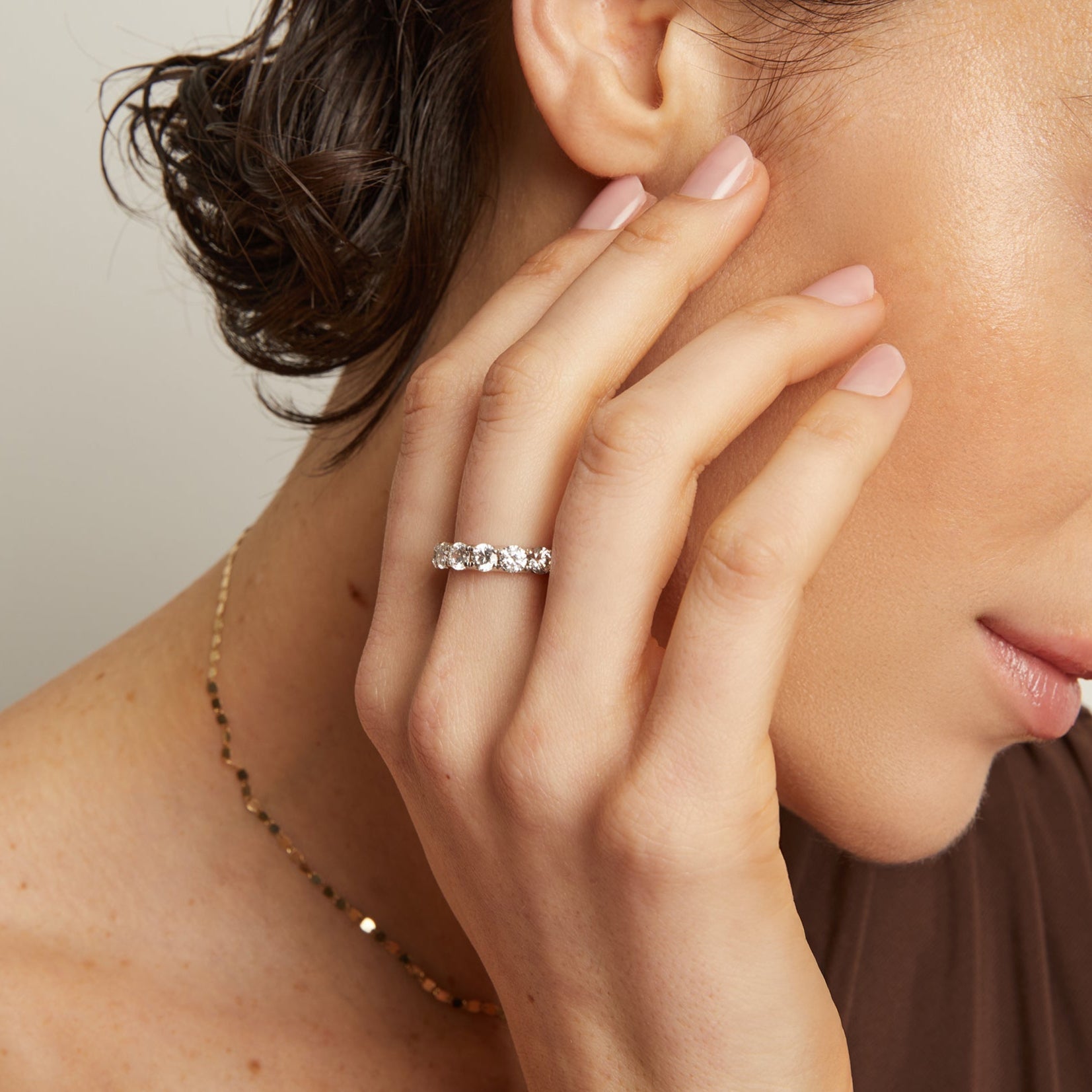 Woman wearing a diamond ring with a neutral background