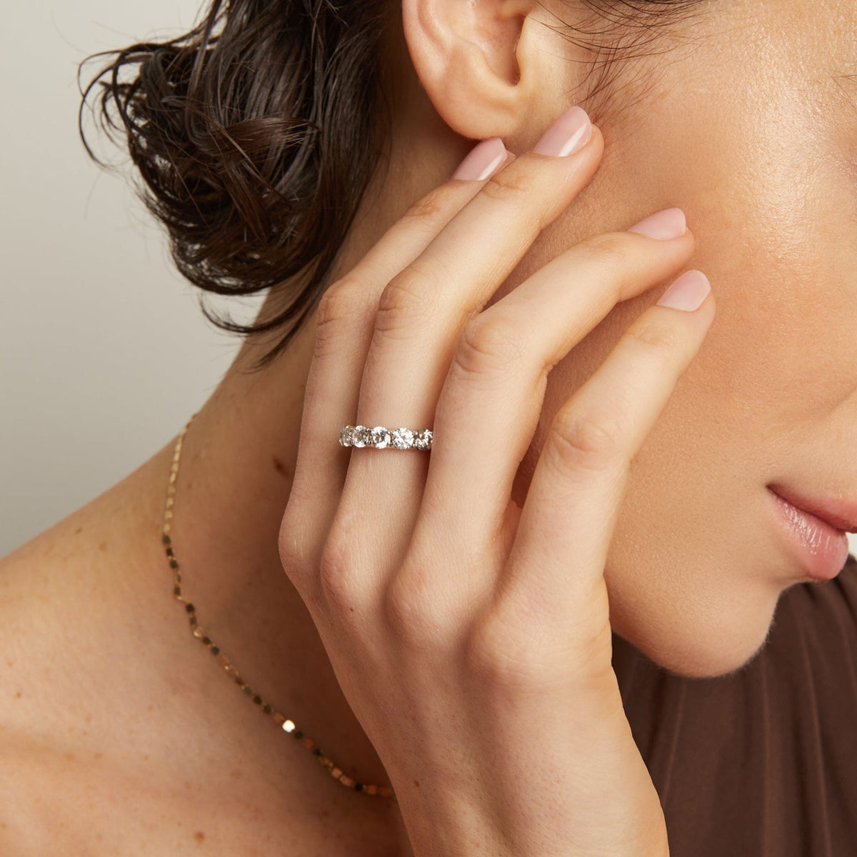 Model. Close-up of a woman wearing a diamond ring, with a neutral background
