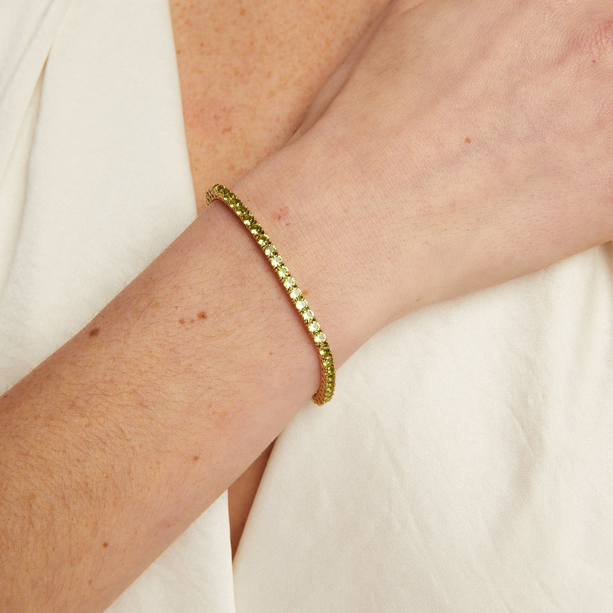 Model. Gold bracelet on a wrist with a white background